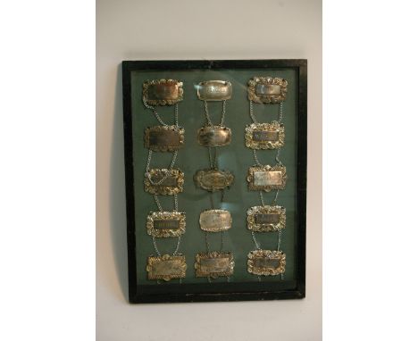 A framed collection of fifteen decanter labels
