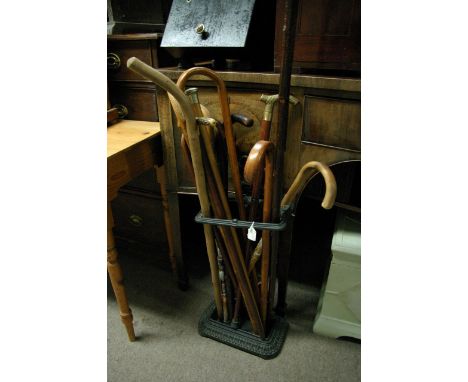 A cast iron stick stand containing walking sticks.