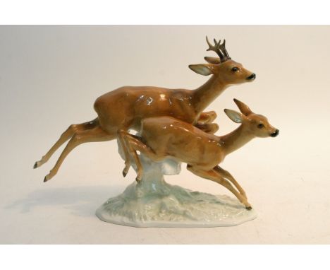 A ceramic figural group of two leaping deer.