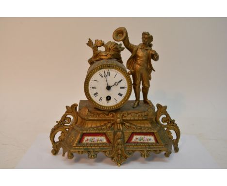 A French Gilt Mantel clock inset with porcelain panels flanked by a figure the enamel dial with roman numerals