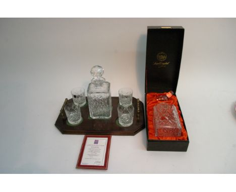 A boxed Webb crystal decanter and a Stuart crystal decanter and four tumblers on a mahogany stand.