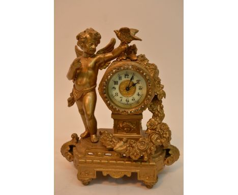 A gilt metal mantel clock flanked with a cherub holding a bird and flowers with foliage. The dial having Arabic numerals