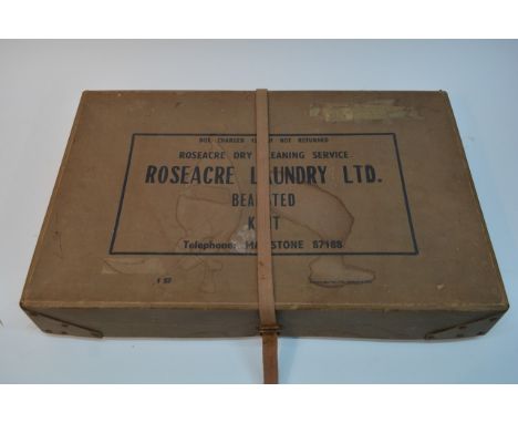 A vintage lady's green velvet dress in a dry cleaning box