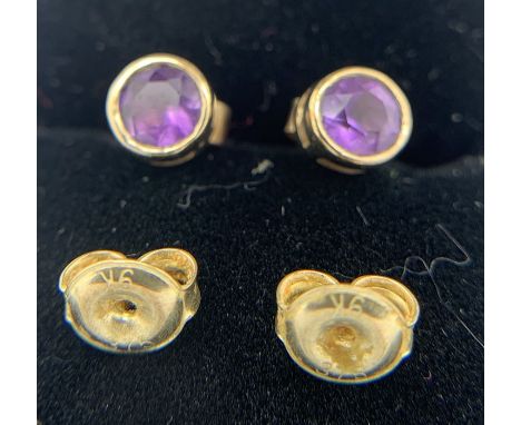 Pair of 9ct gold stud earrings set with amethyst with two 9ct gold earring backs. 1.4gms total. 