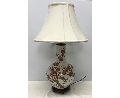 Chinese pottery table lamp on carved wooden base, Cherry Blossom pattern. Lamp 39cms h with shade 67cms h. Condition ReportNe