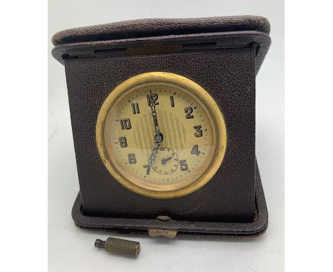 A 'Goliath' style travel alarm clock in original travel case with winding key. 