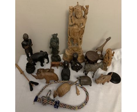 A large quantity of mostly wooden, ceramic and soapstone figures plus a beadwork whip and skin covered drum. Condition Report