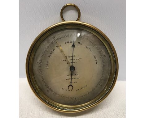 Brass cased circular Aneroid Barometer J Sewill Liverpool, makers stamp to the back D.C. with an anchor 12.5cms w x 5.5cms d.