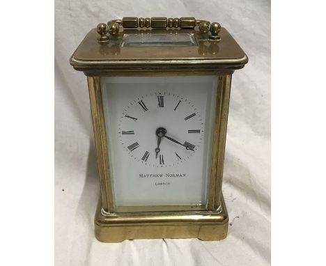 Brass carriage clock, Matthew Norman London, 11cms h not including handle, 8 w x 7cms d. Condition ReportWith key, appears to