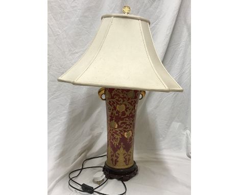 Chinese pottery tall table lamp, gilt and red, floral and leaf design, brass finial with a cream coloured shade. 79cms h incl