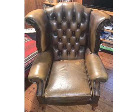 Two button backed winged leather armchairs. 111h x 88w x 76d cm.Condition ReportBoth a/f to leather and cushions, in need of 