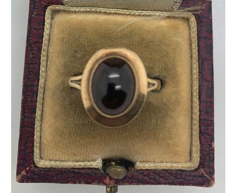 A 9ct gold dress ring set with dark red stone, size P.  3.1gms.Condition ReportSurface scratches to gold and to the top of th