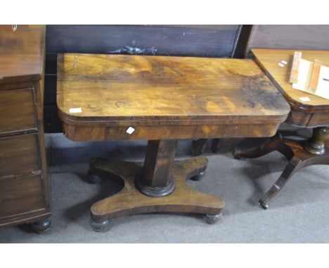 A late Georgian mahogany fold over card table with baize lined interior raised on a tapering column over a platform base with