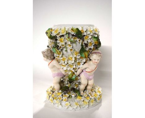 A large 19th Century porcelain vase or lamp base, the vase supported by three putti amongst floral encrusted body, 26cm high