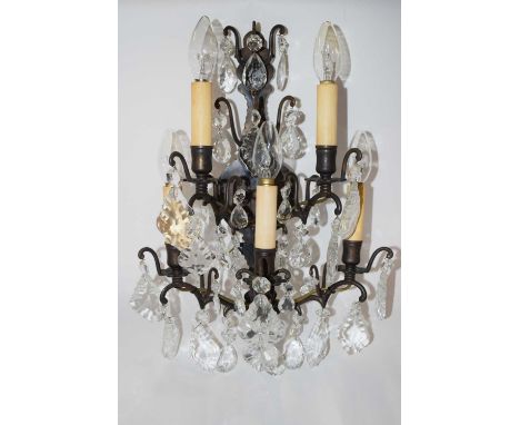 A group of four metal wall lamps with glass droplets, each lamp with five light fittings, mid 20th Century