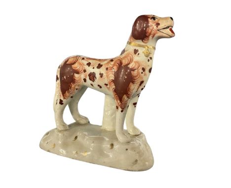 A 19th Century Staffordshire model of a dog with sponged decoration on shaped base, 9cm long