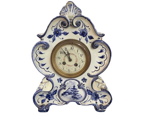 An early 20th Century Delft shaped mantel clock, the dial with painted floral decoration to the centre