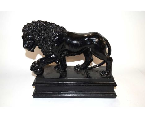 Black painted ceramic model of a Medici lion on a rectangular base, 30cm long