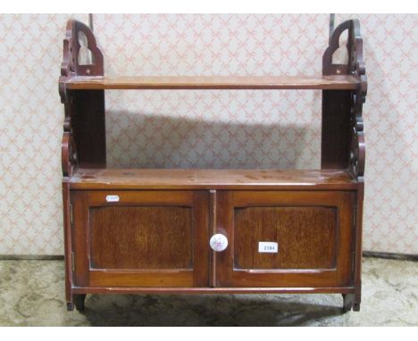 A Victorian mahogany wall shelf partially enclosed by two panelled doors with pierced sides, together with a small waxed pine