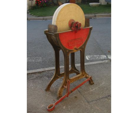 A vintage sharpening/wet stone cradled in a cast iron stand stamped R Melhuish &amp; Sons, Fetter Lane, London 