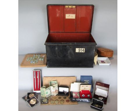 A tin deed box fitted with a collection of interesting items to include a solitaire board, a cased rotary watch 