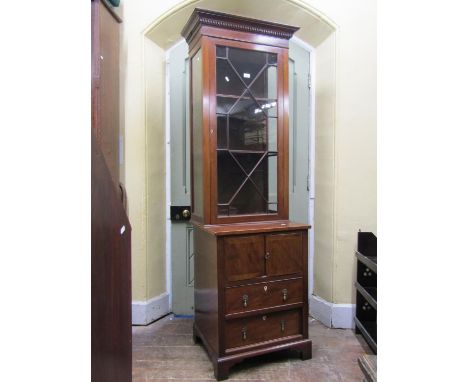 An antique mahogany side cabinet, the lower section enclosed by a pair of panelled doors and two frieze drawers, set on brack
