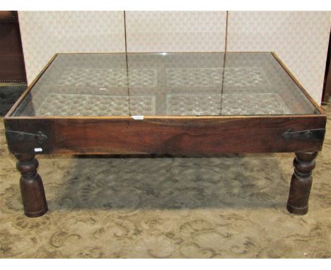 A colonial hardwood occasional table enclosing earlier salvaged architectural panels, set within a frame with iron banded bor