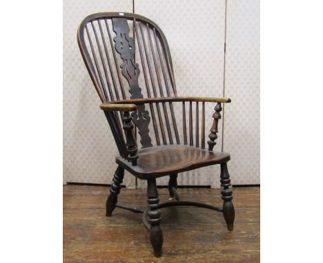 A Georgian comb back elbow chair, principally in elm and ashwood, with turned supports and crinoline stretcher, with pierced 