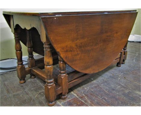 A good quality oak gateleg table with double gate action, raised on turned supports, together with eight (6+2) ladder back ch