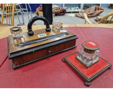 A late Victorian mahogany inkstand, the ebonised handle flanked by glass inkwells above a drawer together with a glass inkwel