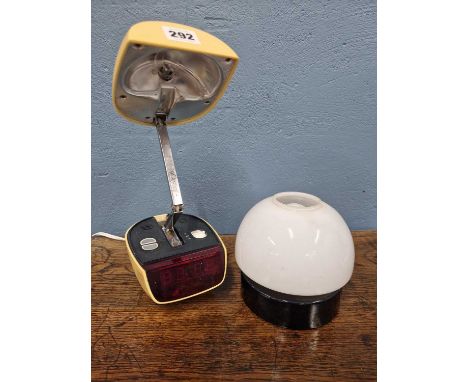 A yellow plastic table lamp/alarm clock adjustable into a pod form together with another table lamp with a mushroom cap shape