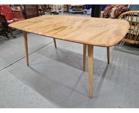 An Ercol beech and elm extending dining table with two additional leaves.