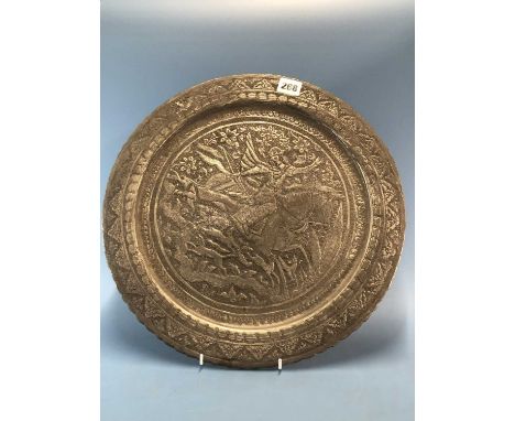 A Persian zinc plated copper dish embossed and engraved with an equestrian bowman hunting with hounds.   Dia. 39.5cms.