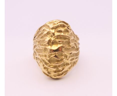 An unmarked gold ring of textured form, probably 18 ct gold. Ring size K/L. 12.8 grammes. 