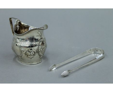 A George III silver cream jug, hallmarked for London 1810 and a pair of George III Irish silver sugar tongs, hallmarked for D