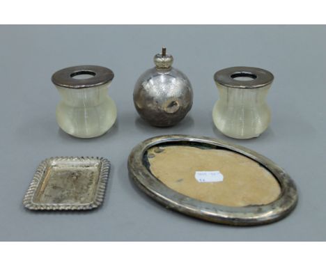 A pair of silver topped match strikers, a small silver dish, a table lighter and a silver frame. The former each 6.5 cm high.