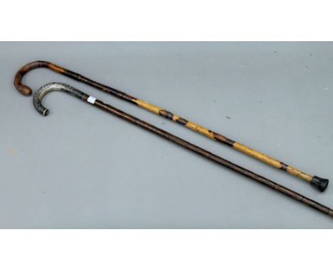 An unmarked silver handled walking stick and another.