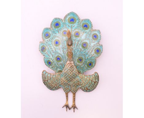 An enamel and silver gilt articulated peacock form brooch.  6.5 cm high.