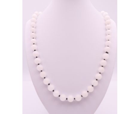 A white jade bead necklace.  Approximately 70 cm long.