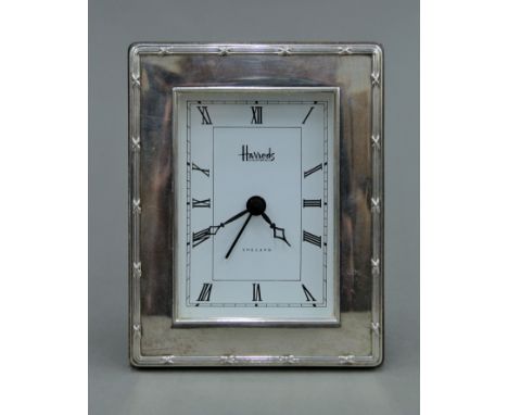 A silver Harrods clock. 9 cm wide.