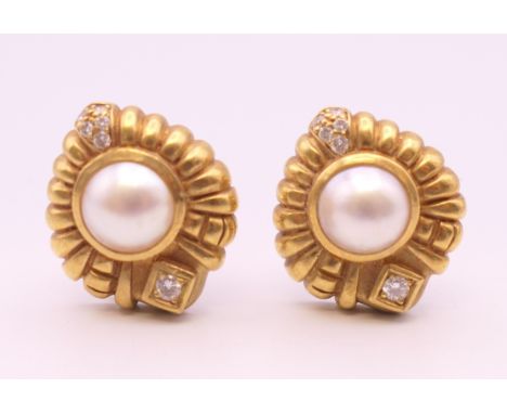 A pair of 18 K gold pearl and diamond earrings. 16.5 grammes total weight.