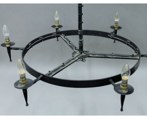 A circular black painted metal chandelier. Approximately 90 cm diameter.