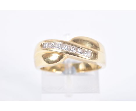 AN 18CT GOLD DIAMOND SET RING, seven princess cut diamonds channel set in yellow gold, cross over mount, hallmarked 18ct Lond