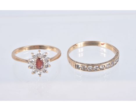 TWO YELLOW METAL GEM SET RINGS, the first an oval cluster set with an oval cut garnet and colourless cubic zirconia, pinched 
