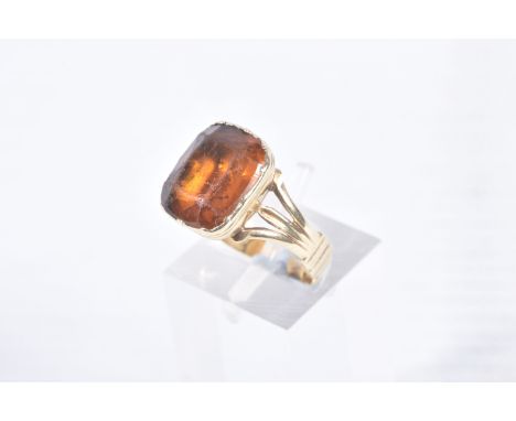 A MID VICTORIAN PASTE RING, the rectangular orange paste in a closed back setting, to the trifurcated shoulders, with persona