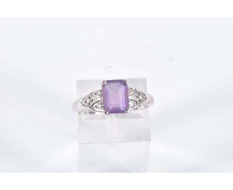 A 9CT WHITE GOLD AMETHYST AND SPINEL RING, set with a rectangular cut amethyst, four claw set, flanked with colourless spinel
