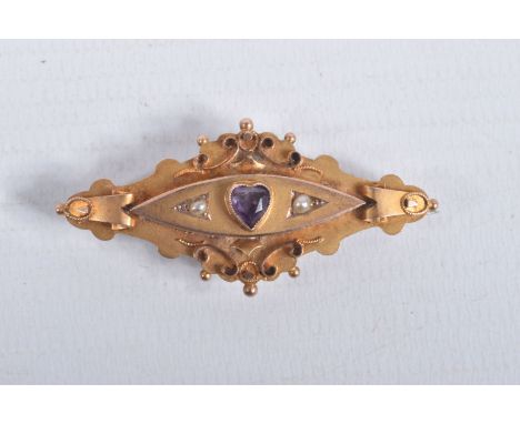 AN EARLY 20TH CENTURY 9CT GOLD GEM SET BROOCH, set with a central heart cut amethyst, flanked with split pearls, to a scroll 