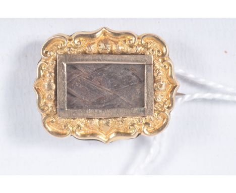 A YELLOW METAL VICTORIAN MOURNING BROOCH, small brooch of wavy outline, with a woven hair insert to the centre, personal engr
