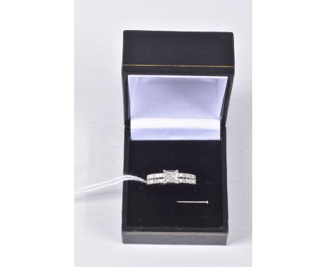 A 9CT WHITE GOLD DIAMOND RING, four princess cut diamonds in an invisible setting leading on to split shoulders set with twen