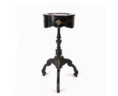 A late 19th/early 20th century French ebonised bijouterie table with a red silk lining, gilt mounts a turned stem and tripod 